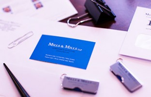 Picture of Mills & Mills logo among office supplies