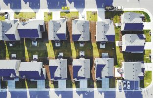Overhead street view of suburban homes.